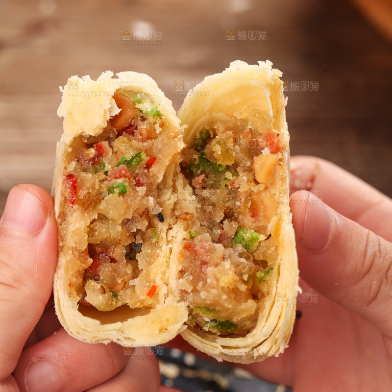 手拿着掰开的酥皮月饼
