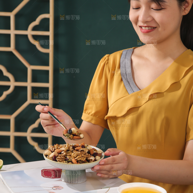 女孩端着一盘坚果组合