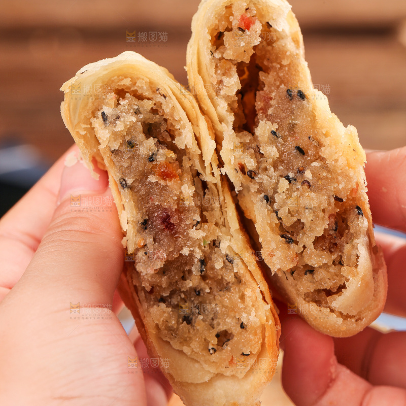 手拿着掰开的酥皮月饼