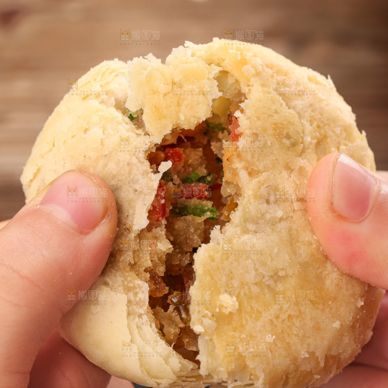 手拿着掰开的酥皮月饼