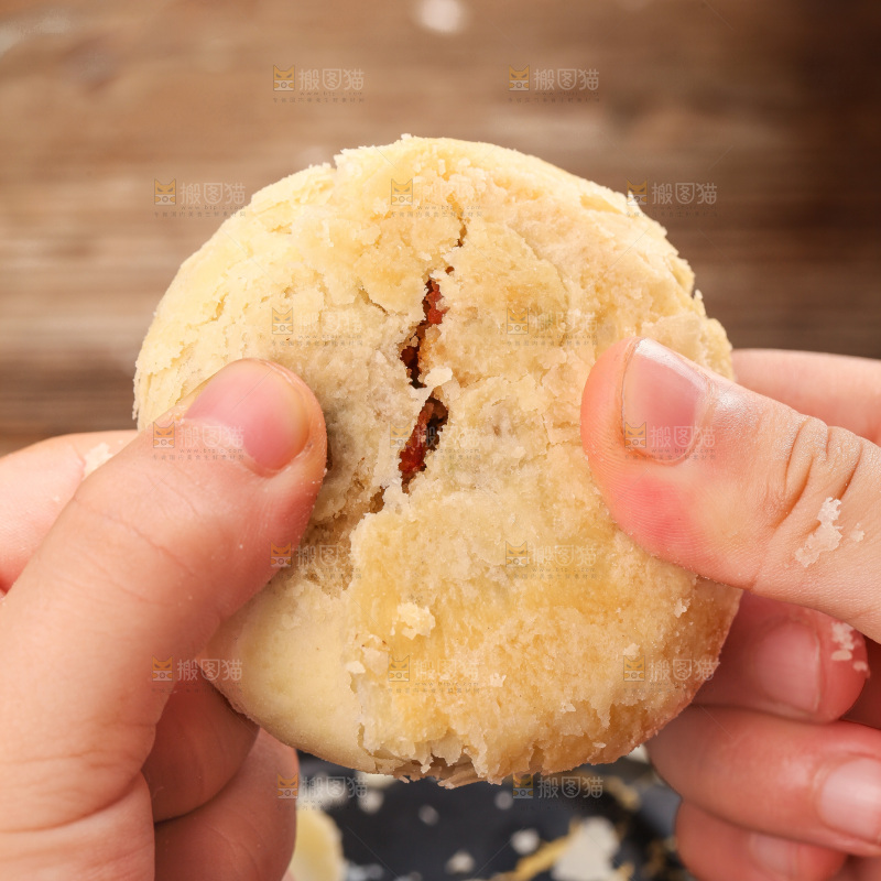 手拿着掰开的酥皮月饼