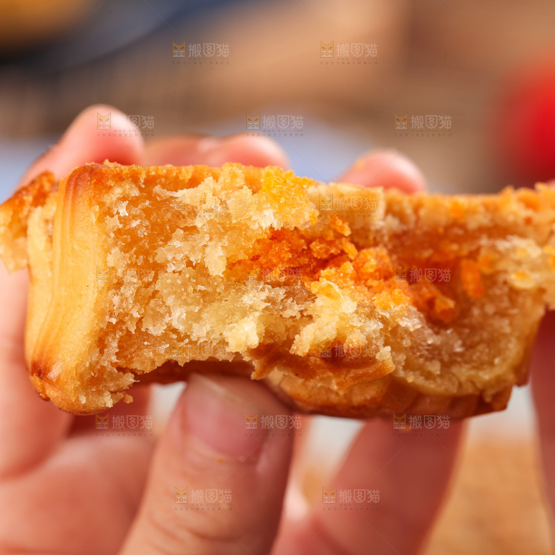 手拿着掰开的蛋黄月饼