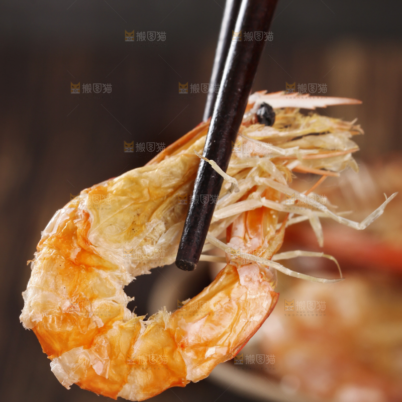 筷子上夹着碳烤虾