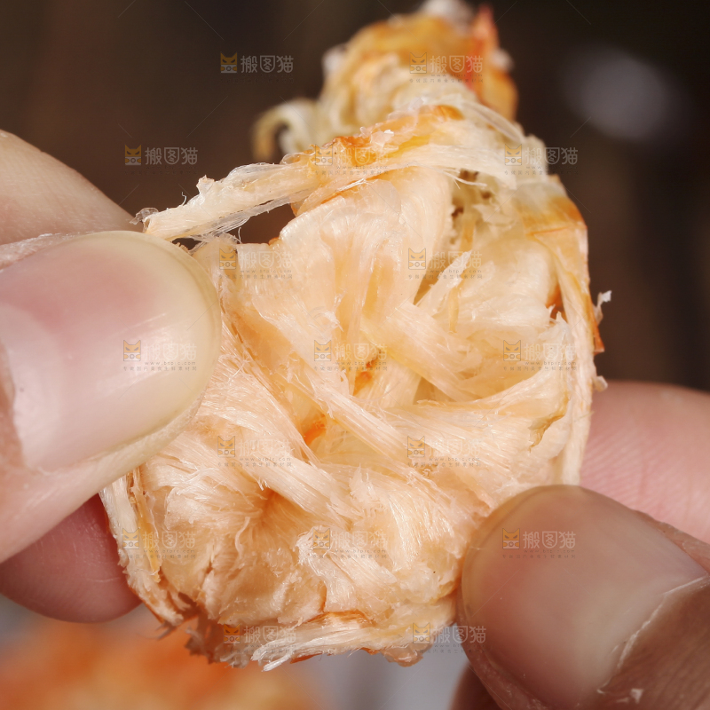 手拿着烤虾干