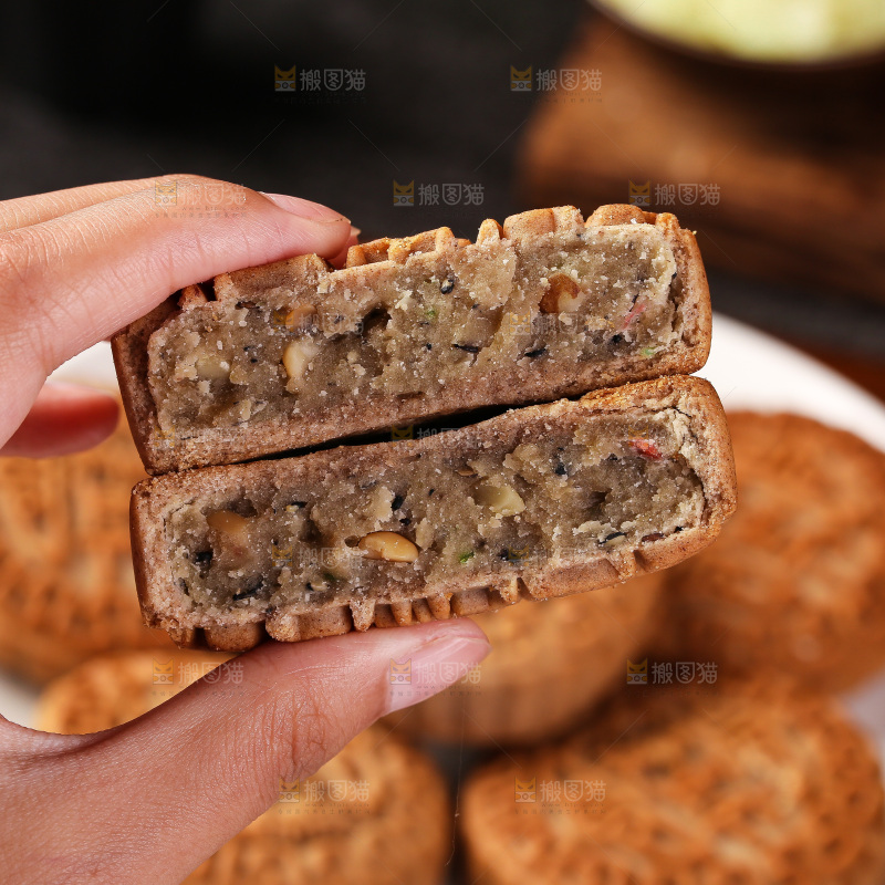 手拿着掰开的荞麦五仁月饼
