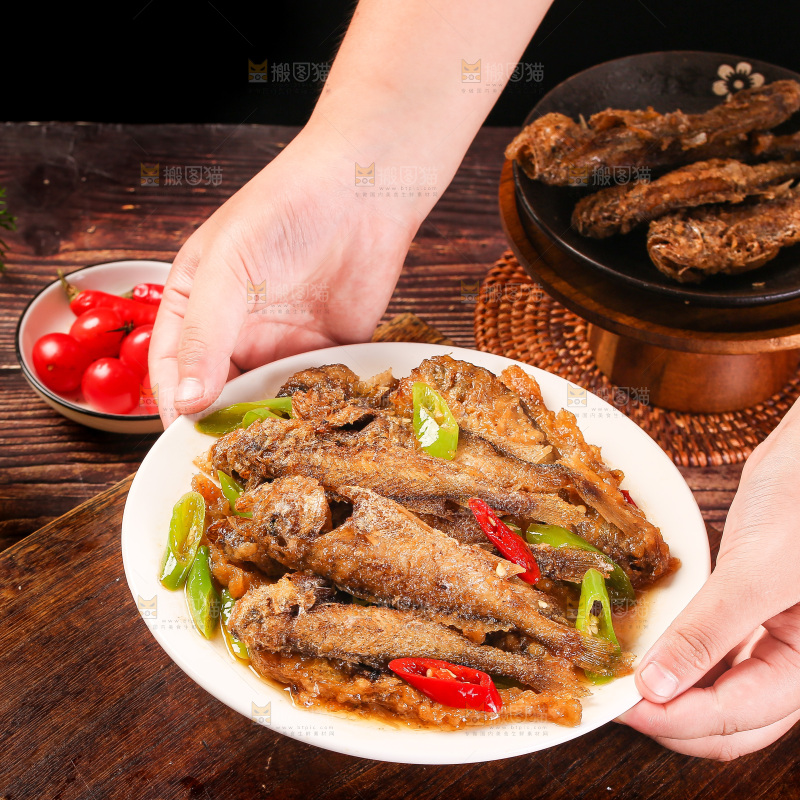 手端着一盘香酥煎鱼