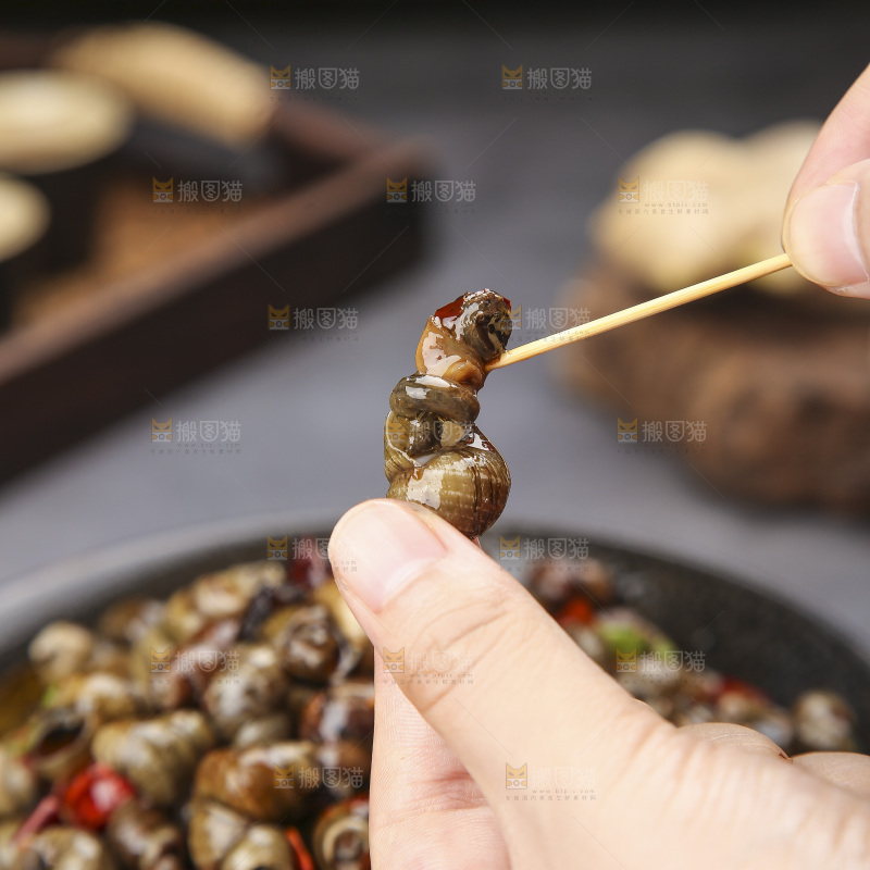 手里拿着牙签挑田螺肉
