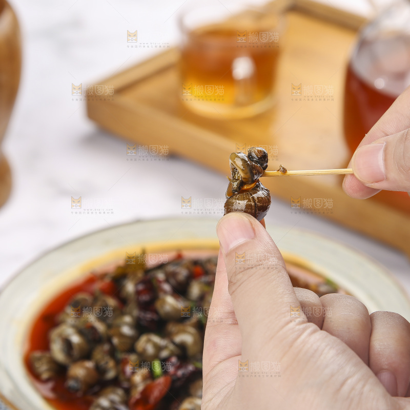 手里拿着牙签挑田螺肉