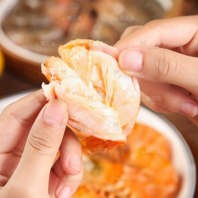手里拿着剥开的虾肉