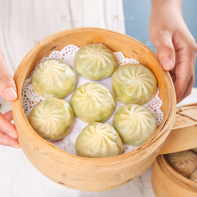 手端着一笼小包子