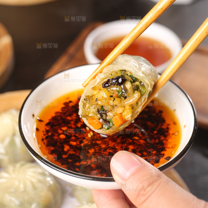 筷子上夹着蘸酱的包子