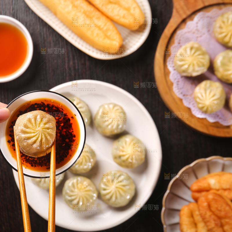 筷子上夹着蘸酱的包子