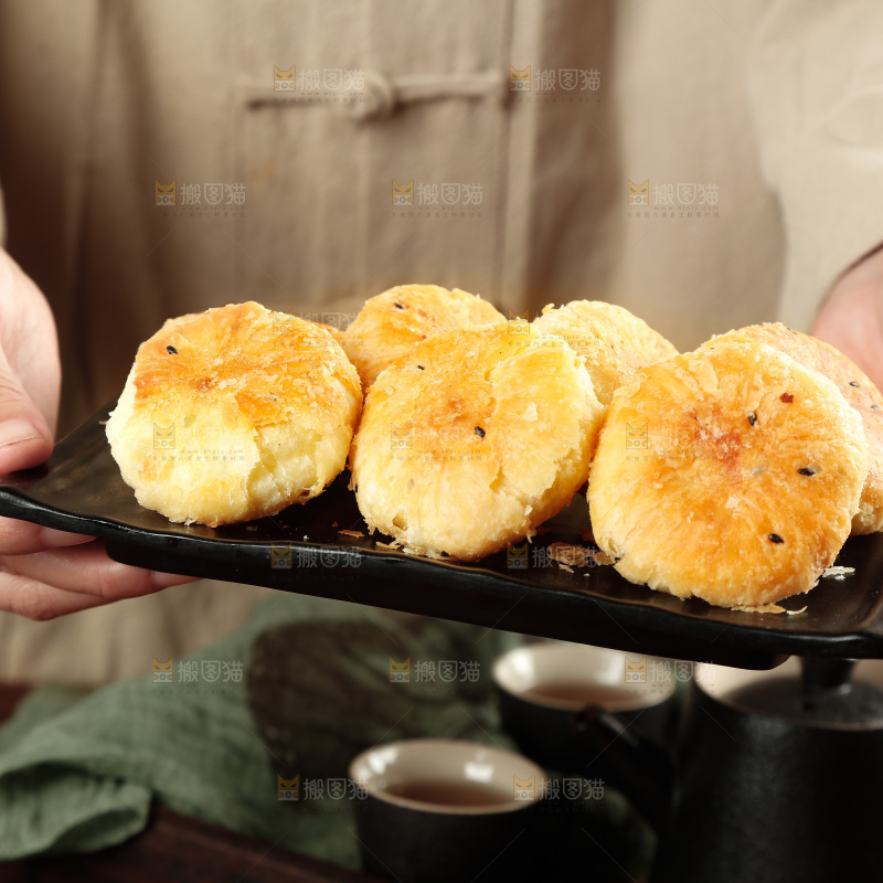 手里端着一盘酥饼