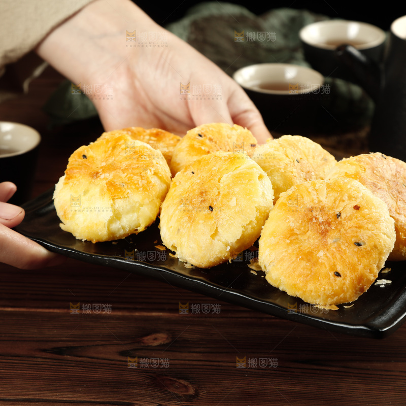 手里端着一盘酥饼