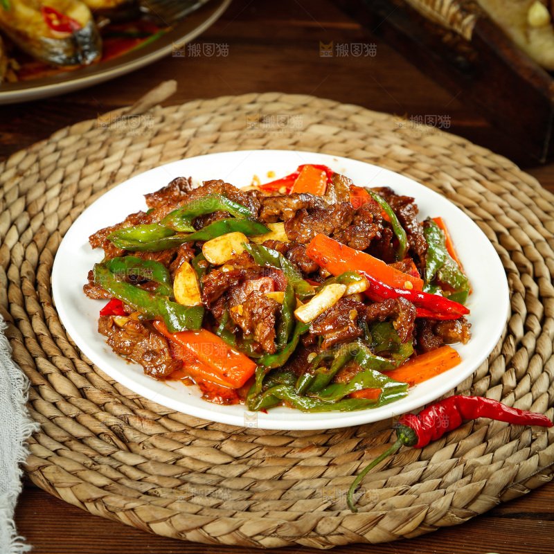 垫子上摆放着一盘青椒炒牛肉
