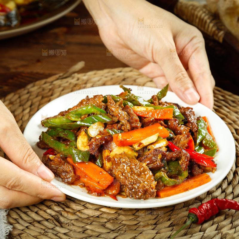 手里端着一盘辣椒炒牛肉