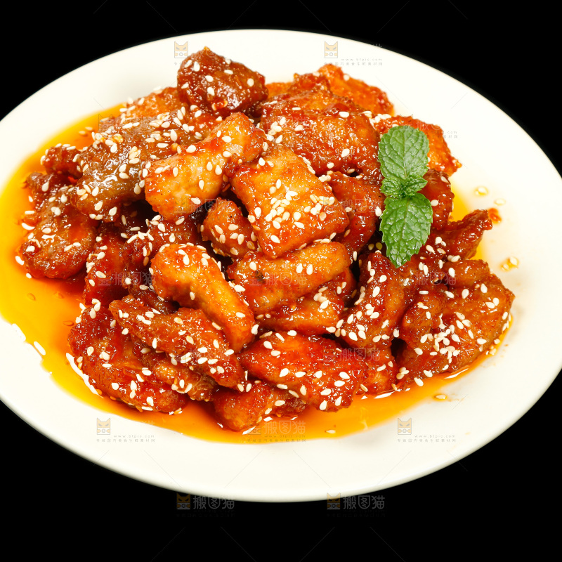 一盘糖醋里脊肉摆在黑底上