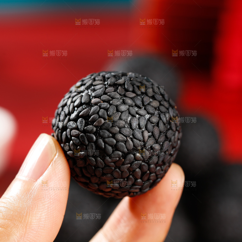 手里拿着芝麻丸子