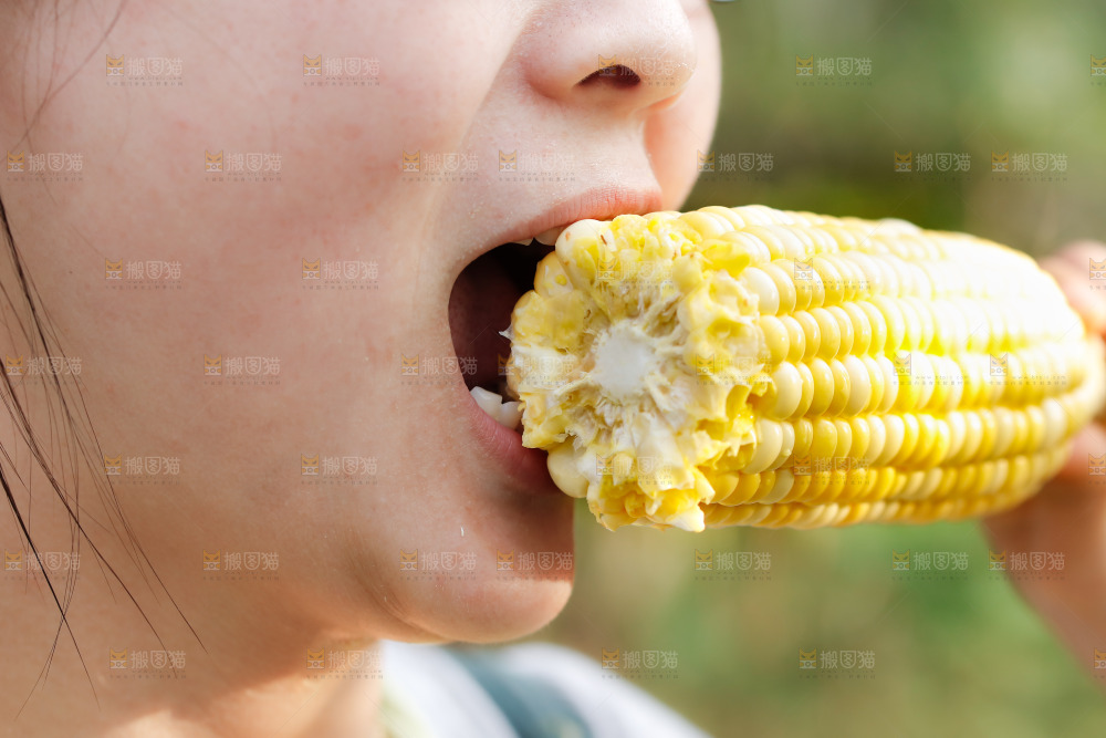 手里拿着甜玉米