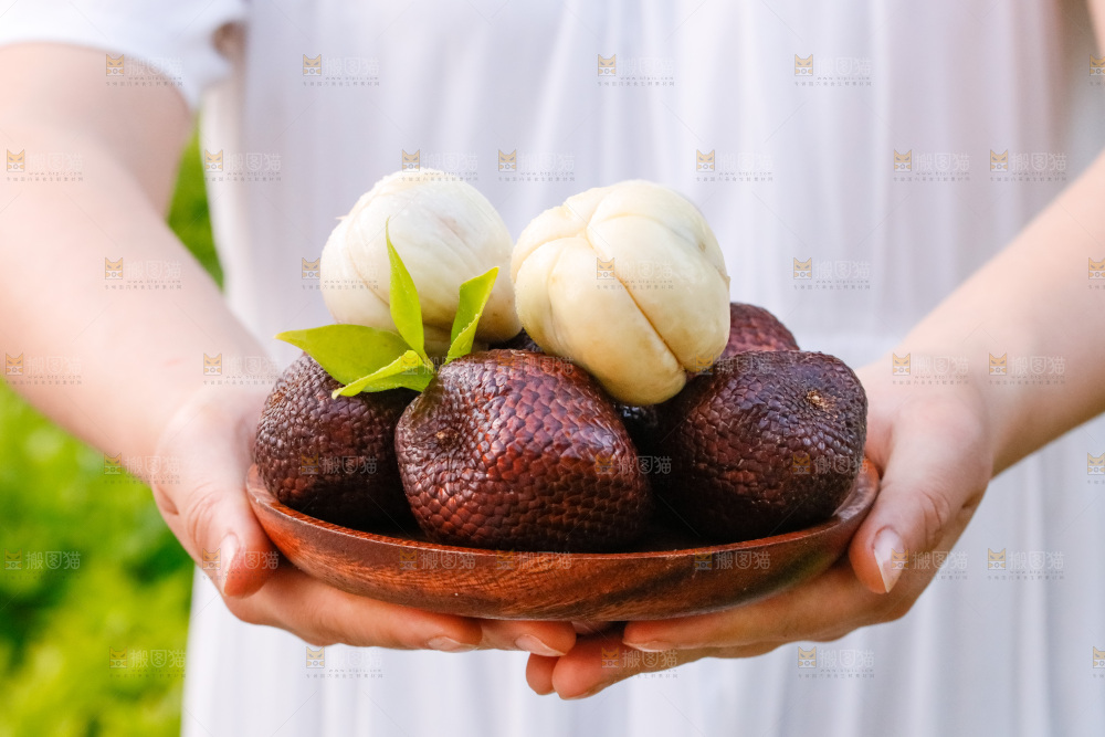 手里拿着蛇皮果