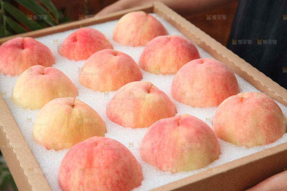 手里拿着一箱阳山水蜜桃