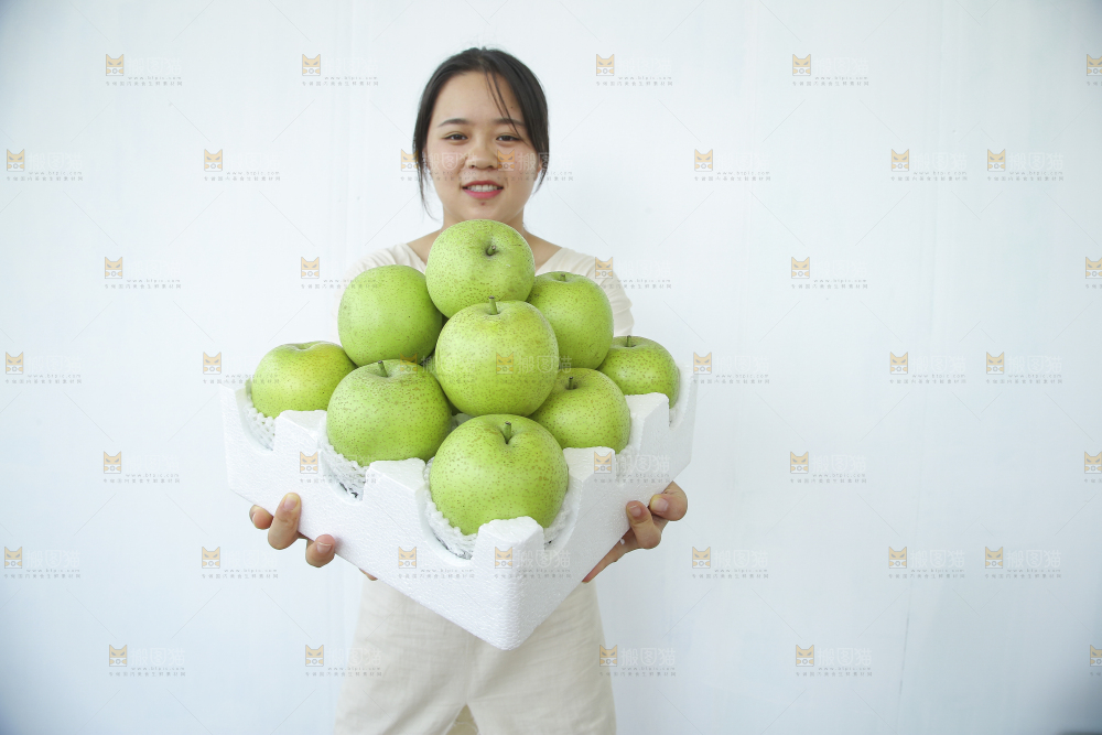 手里拿着一盒青皇冠梨