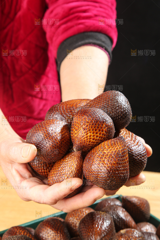 手里拿着蛇皮果