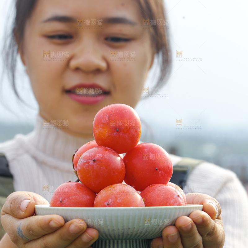 手里拿着珍珠蜜柿